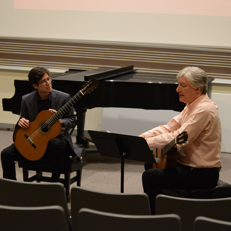 Guitar teacher interacting with student during the Guitar Festival.