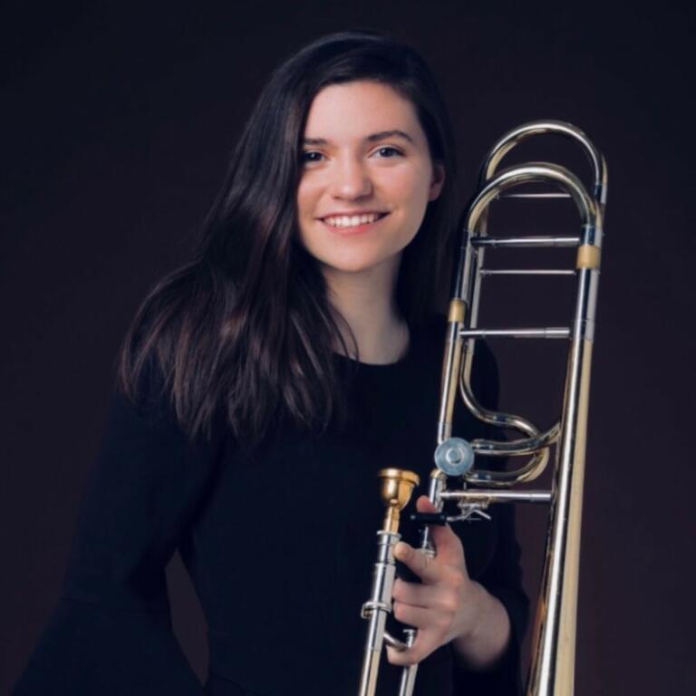 Woman smiling holding trombone