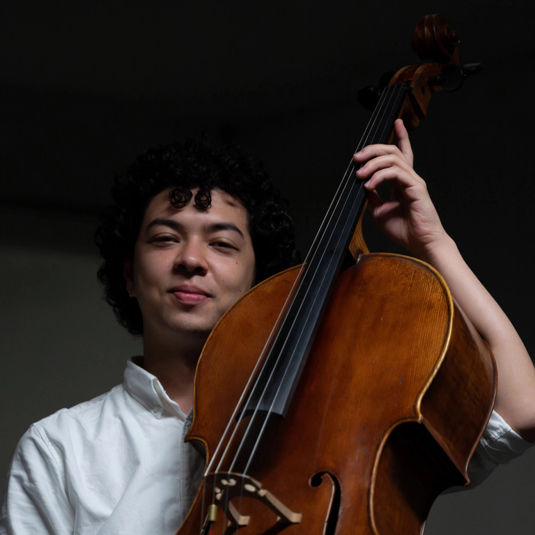 Man smiling holding a cello